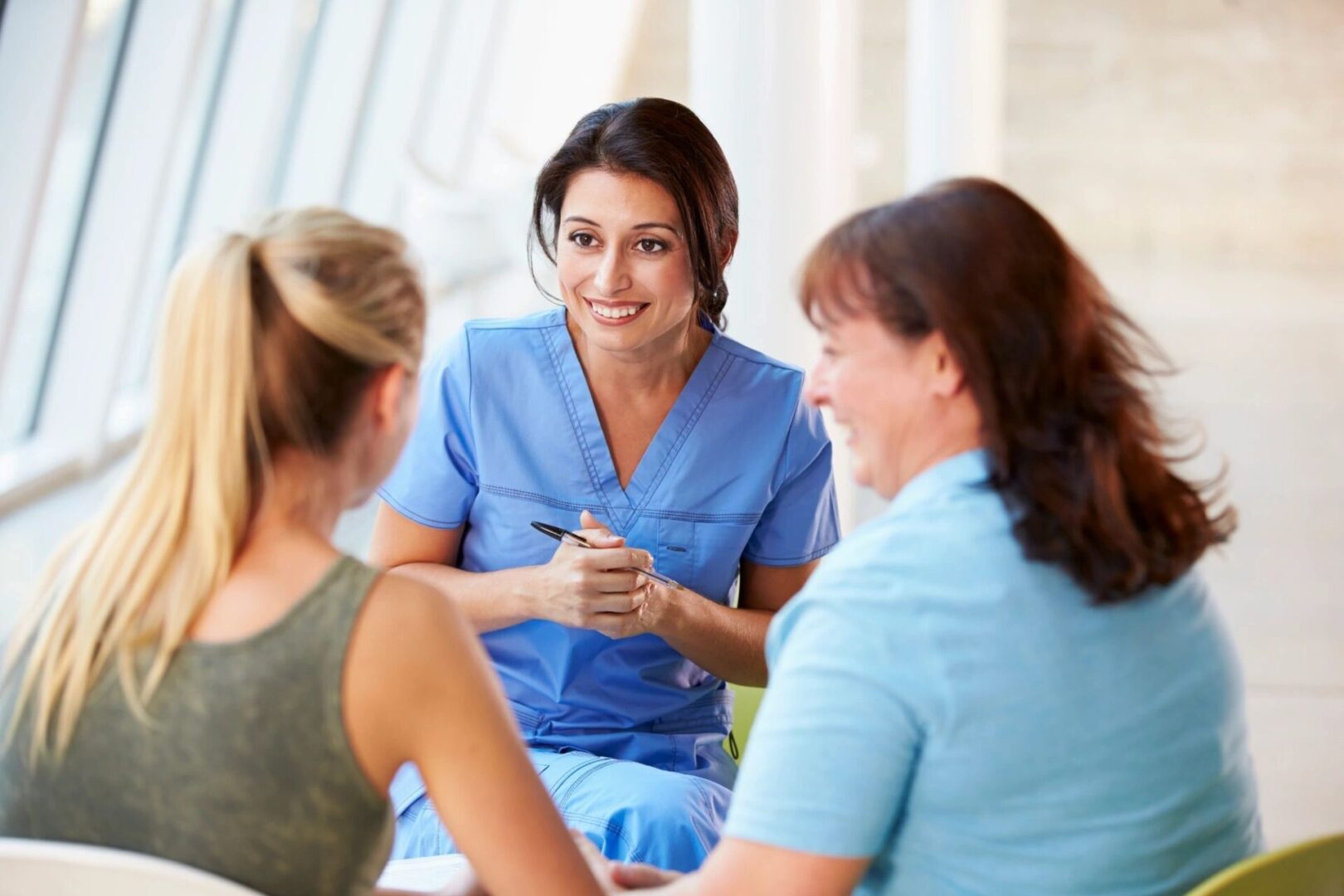 A group of women sitting around talking to each other.