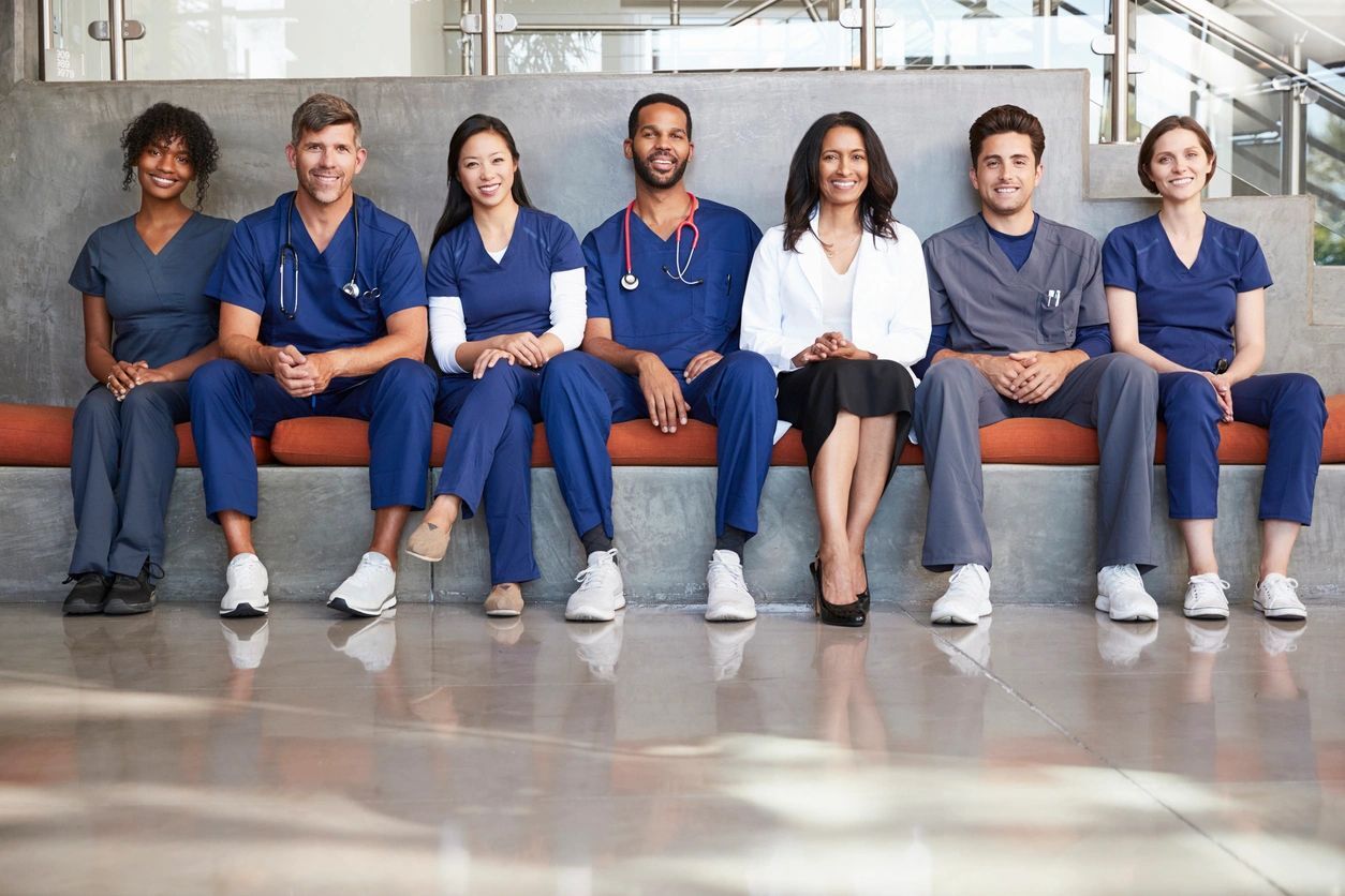 A group of doctors sitting on top of a bench.